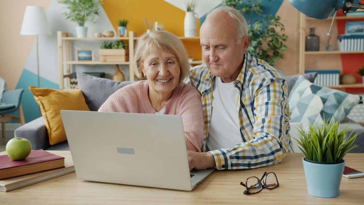An older couple looking at a laptop together