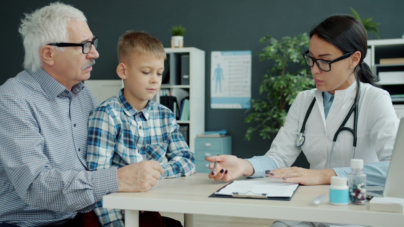A grandfather and his grandson at a doctor's appointment