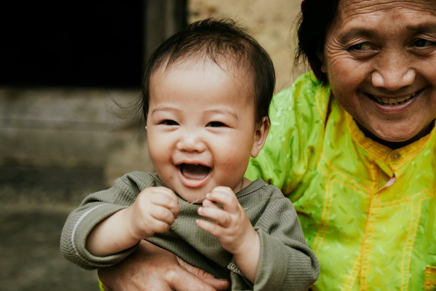 A grandmother holding her laughing grandchild