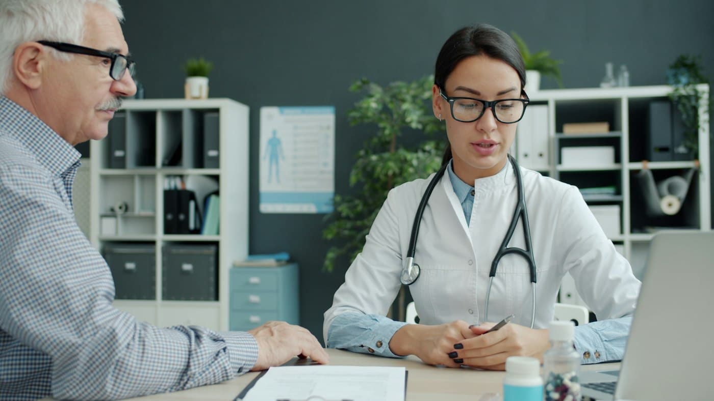 A doctor going over paperwork with an older patient in her office